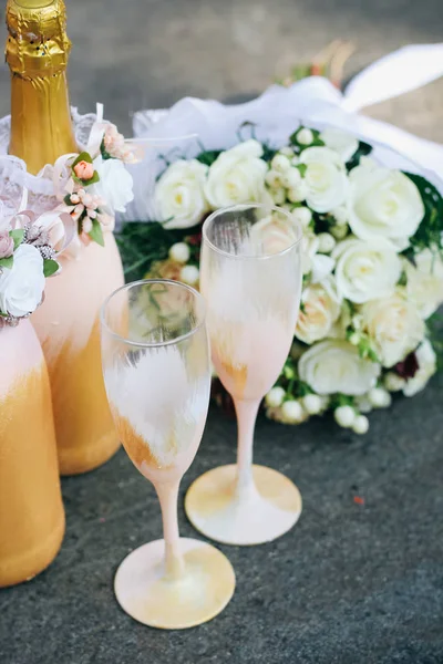 Wedding decor of champagne bottles and glasses in gold tones