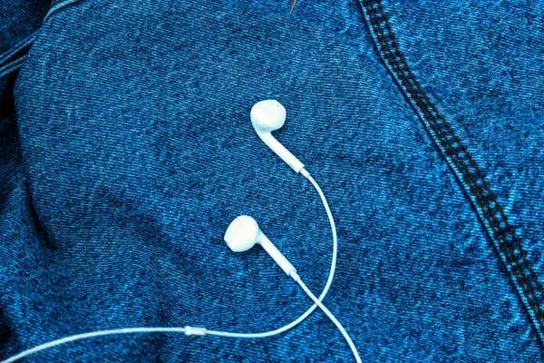 Kot arka planda beyaz kulaklıklar var. Yukarıdan görüntüle