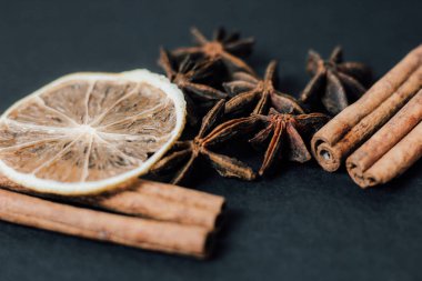 Geleneksel Noel baharatları - Tarçınlı yıldız anason ve koyu arkaplanda kuru kireç.