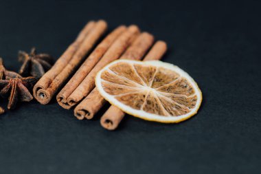 Geleneksel Noel baharatları - Tarçınlı yıldız anason ve koyu arkaplanda kuru kireç.