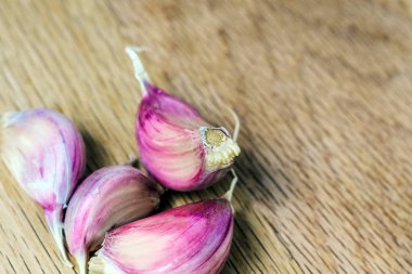 Ahşap bir arka planda sarımsak karanfilleri. Mor sarımsak