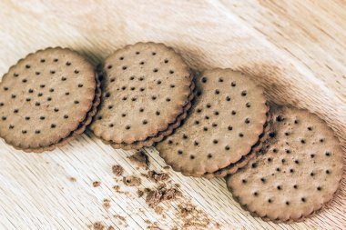 Tahta üzerinde delikleri olan çıtır çikolatalı kurabiye. Dolu Yuvarlak Kurabiyeler