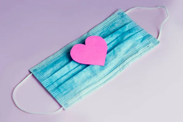 Tıbbi bir bandaj üzerinde pembe kağıt kalp. Kavram.