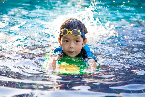 Chłopiec się nauczyć pływać w basenie — Zdjęcie stockowe