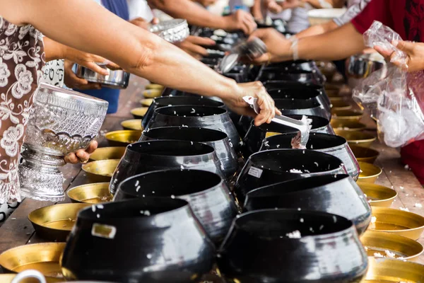 Άνθρωποι βάζουν ρύζι μέσα στο μπολ του μοναχού στο ιερή ημέρα — Φωτογραφία Αρχείου