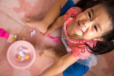 küçük oyuncakları yere oynarken bir gülücük ver