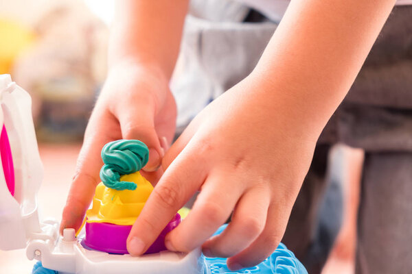 Дети играют тесто с плесенью, чтобы сделать много смешных форм из
 