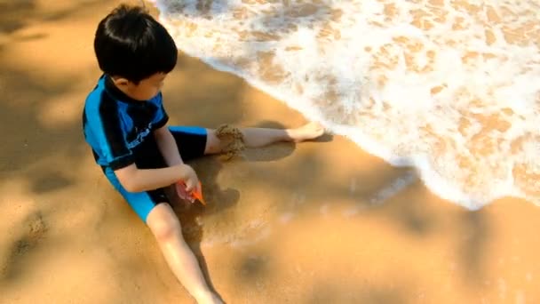 Pojke Badkläder Sittande Stranden Och Spela Sand Vid Havet Den — Stockvideo