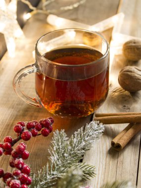 Ahşap bir masada cam bir kapsülün içinde tatlı marshmallow ile kış çay partisi. Bir fincan çay için Noel ışıkları, yıldız çelengi, ceviz ve tarçın çubukları. Noel havası