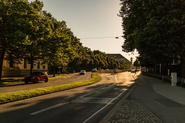 在阴凉的城市环境中 阳光灿烂的一天 汽车沿着绿树成荫的双行车道行驶 — 图库照片