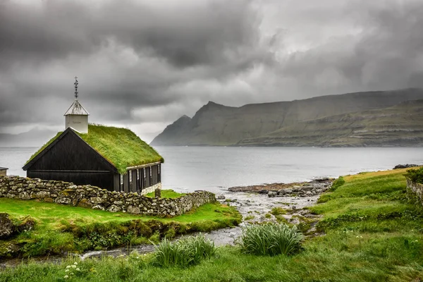 Pequeña iglesia del pueblo bajo nubes pesadas — Foto de Stock