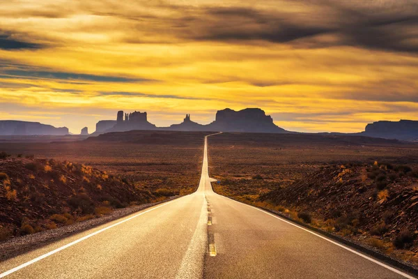 Έρημο δρόμο που οδηγεί στο Monument Valley στο ηλιοβασίλεμα — Φωτογραφία Αρχείου