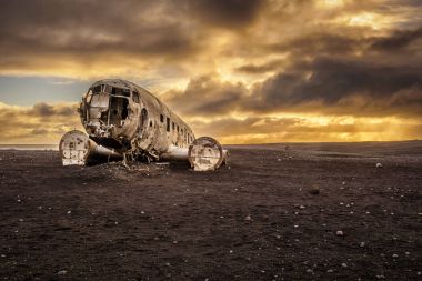 Old crashed plane in Iceland with heavy storm clouds  clipart
