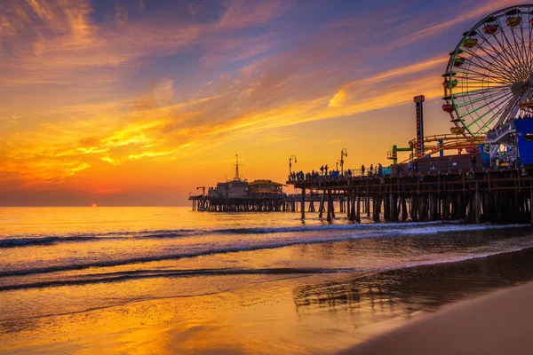 Los visitantes disfrutan de la puesta de sol sobre el muelle de Santa Mónica en Los Ángeles — Foto de Stock