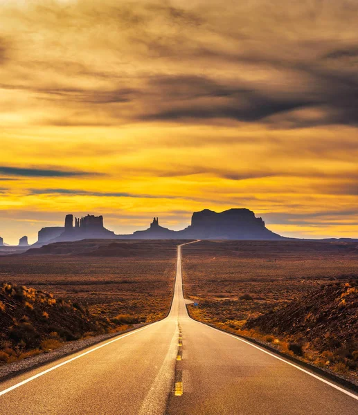 Έρημο δρόμο που οδηγεί στο Monument Valley στο ηλιοβασίλεμα — Φωτογραφία Αρχείου