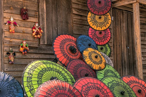 Colorful paper umbrellas on a wooden wall — Stock Photo, Image