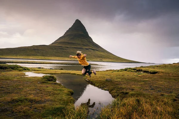 젊은 등산객 이 아이슬란드의 케르크주 폴 산에서 개울을 뛰어 넘는 모습 — 스톡 사진