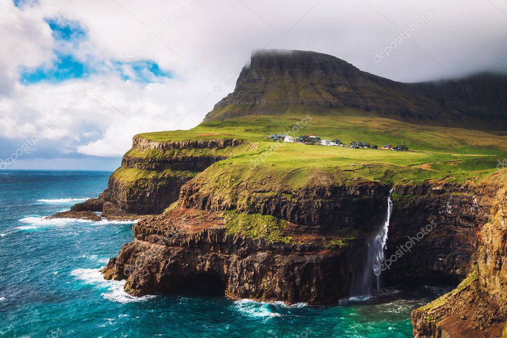 Gasadalur village and its waterfall under strong wind, Faroe Islands, Denmark