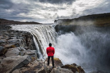 İzlanda 'daki Dettifoss şelalesinin yanında duran yürüyüşçü.