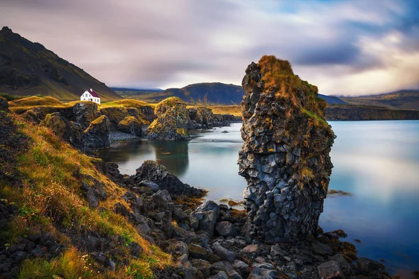 Mořské pobřeží na Islandu s útesy a malý dům v obci Arnarstapi — Stock fotografie