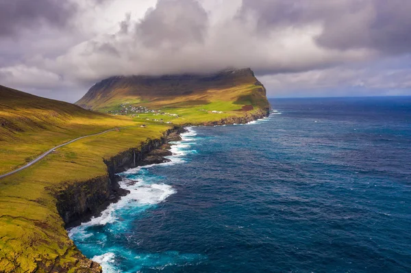 Vue aérienne d'une route longeant la côte jusqu'à un village des îles Féroé — Photo