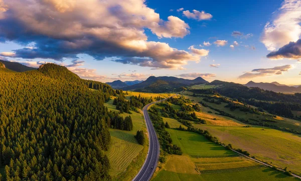 Estrada que atravessa florestas da região de Liptov, na Eslováquia, ao pôr do sol — Fotografia de Stock