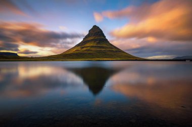 Kirkjufell dağının üzerinde gün batımı İzlanda 'daki bir gölde yansıyor.