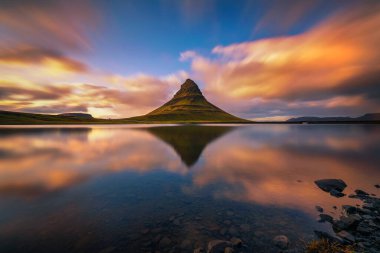 Kirkjufell dağının üzerinde gün batımı İzlanda 'daki bir gölde yansıyor.