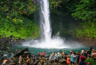 Kosta Rika 'daki La Fortuna şelalesini ziyaret eden turistler ve yerliler