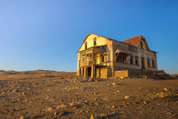 Napkelte egy elhagyatott ház felett Kolmanskop szellemvárosában, Namíbiában. — Stock Fotó