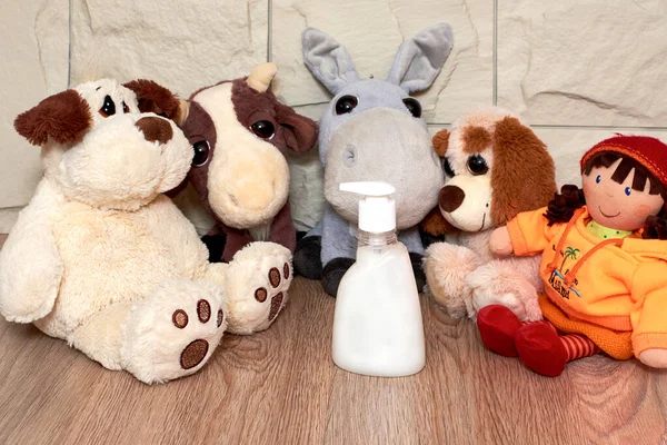 Soft toys dogs, donkeys, dolls are seated for play, liquid soap for the prevention of diseases. Concept of children\'s activities and entertainment in quarantine, during illness