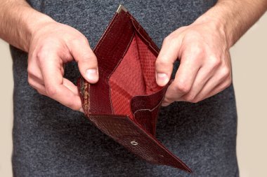 Bir adamın elinde eski püskü kahverengi bir çanta. Kriz, işsizlik, mali yetersizlik kavramı.