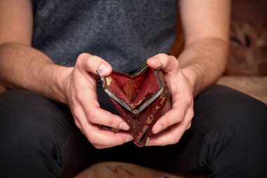 Bir adamın elinde eski püskü kahverengi bir çanta. Kriz, işsizlik, mali yetersizlik kavramı.