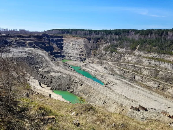 Production of graphite. Industrial background. Deep pit under the open sky.