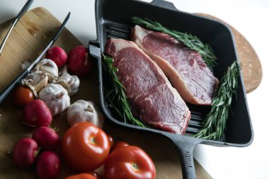 Taze sığır eti. Tavada biftek. Et ve sebze. Mermer biftek. Biberiye ve yağ..