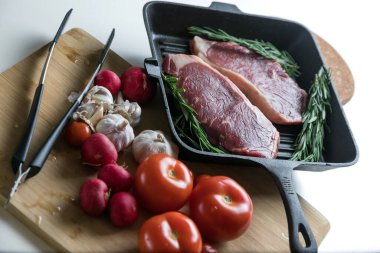 Taze sığır eti. Tavada biftek. Et ve sebze. Mermer biftek. Biberiye ve yağ..