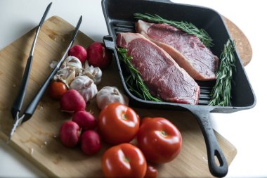 Taze sığır eti. Tavada biftek. Et ve sebze. Mermer biftek. Biberiye ve yağ..