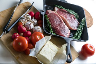 Taze sığır eti. Tavada biftek. Et ve sebze. Mermer biftek. Biberiye ve yağ..