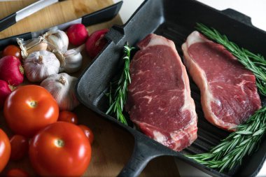 Taze sığır eti. Tavada biftek. Et ve sebze. Mermer biftek. Biberiye ve yağ..