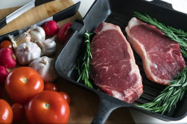 Taze sığır eti. Tavada biftek. Et ve sebze. Mermer biftek. Biberiye ve yağ..