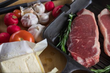 Taze sığır eti. Tavada biftek. Et ve sebze. Mermer biftek. Biberiye ve yağ..