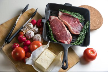 Taze sığır eti. Tavada biftek. Et ve sebze. Mermer biftek. Biberiye ve yağ..