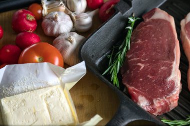 Taze sığır eti. Tavada biftek. Et ve sebze. Mermer biftek. Biberiye ve yağ..