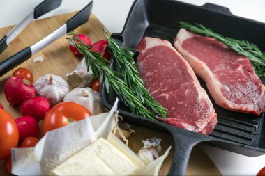 Taze sığır eti. Tavada biftek. Et ve sebze. Mermer biftek. Biberiye ve yağ..