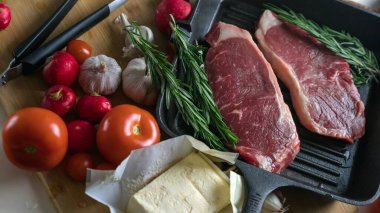 Taze sığır eti. Tavada biftek. Et ve sebze. Mermer biftek. Biberiye ve yağ..