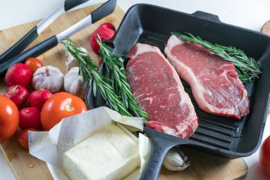 Taze sığır eti. Tavada biftek. Et ve sebze. Mermer biftek. Biberiye ve yağ..