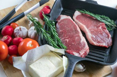 Taze sığır eti. Tavada biftek. Et ve sebze. Mermer biftek. Biberiye ve yağ..