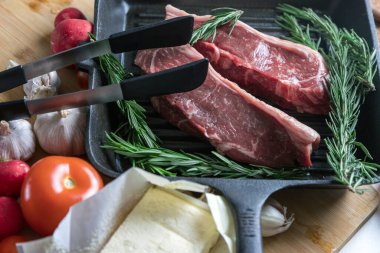 Flütlü tavada kızarmış biftek. Et ve biberiye. Yağ tavada erir..