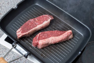 Et parçaları kızartma tavasında pişirilir. Zengin ve sulu biftekler. Et pişiriyorum..