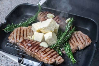 Flütlü tavada kızarmış biftek. Et ve biberiye. Yağ tavada erir..